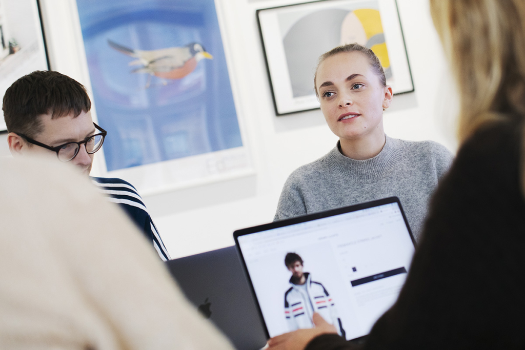 Flera personer sitter i möte med sina datorer.