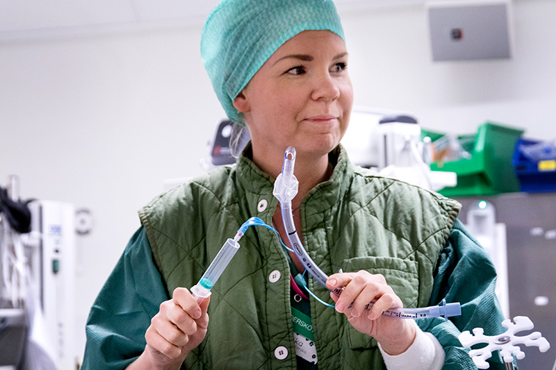 Undersköterska håller i operationsutrustning.