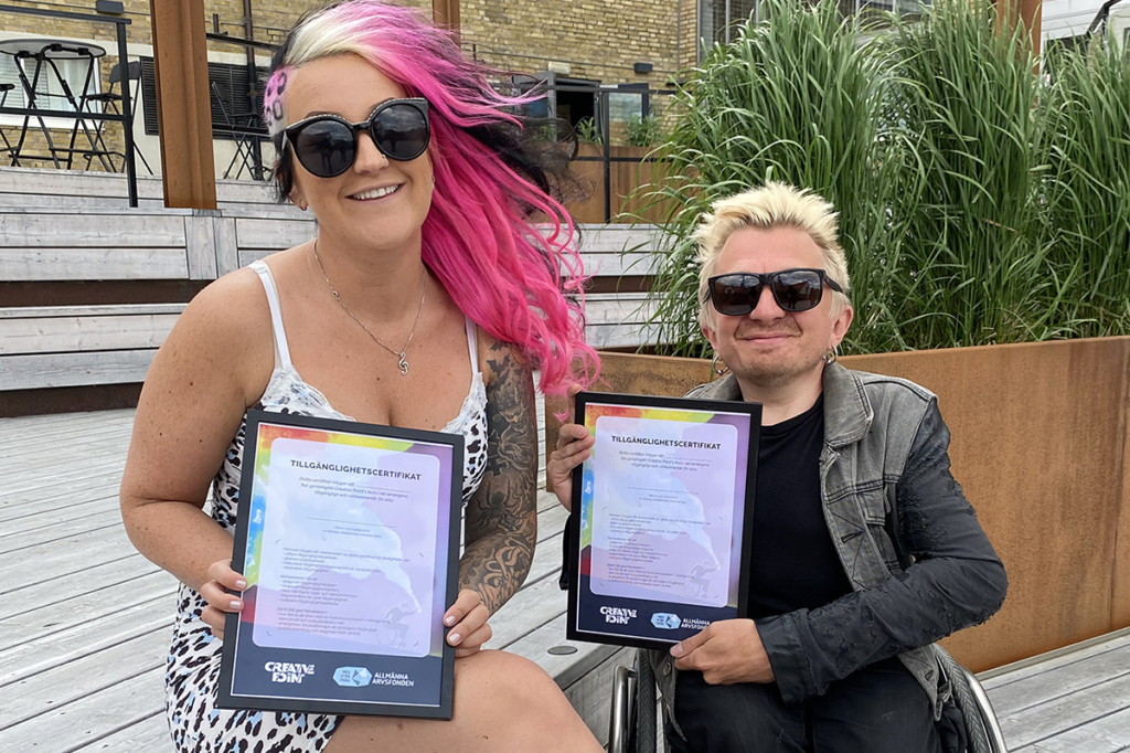 Mirre Sennehed och Eddie Wheeler på Creative Point håller upp varsitt tillgänglighetscertifikat.