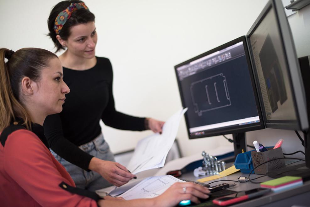 Två kvinnor sitter framför en dator i ett CAD-verktyg